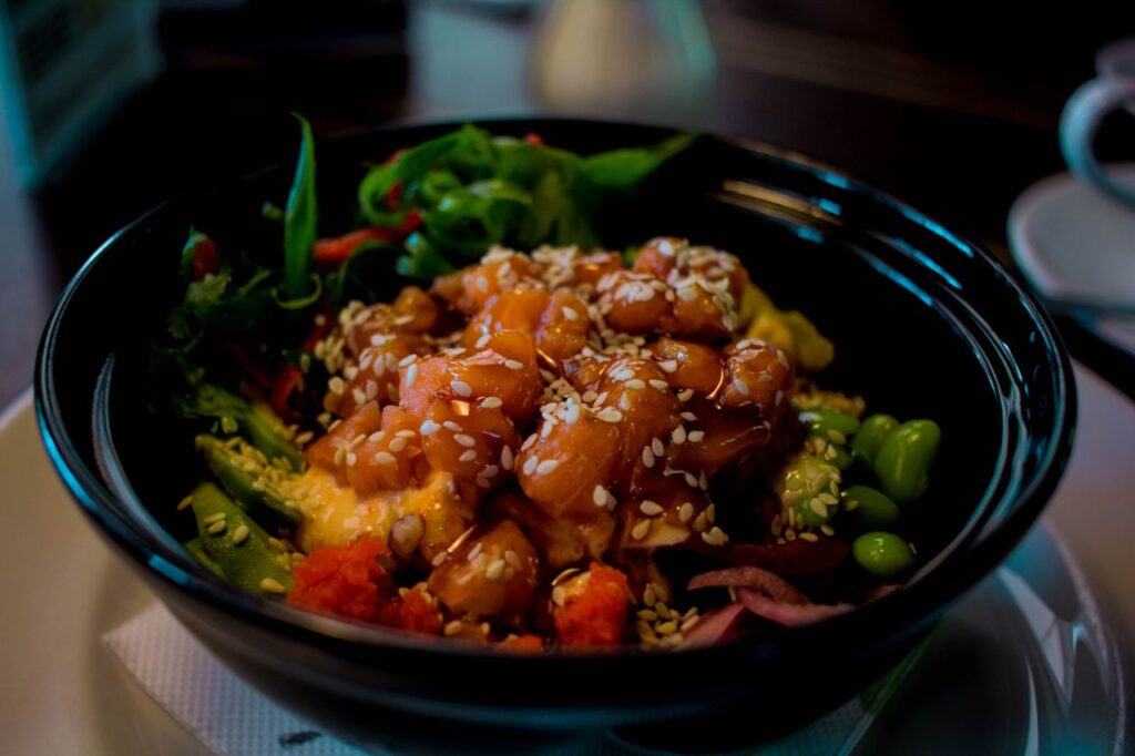 Poke Bowl mit Lachs, Avocado und Sesam, typisches Hawaii-Gericht