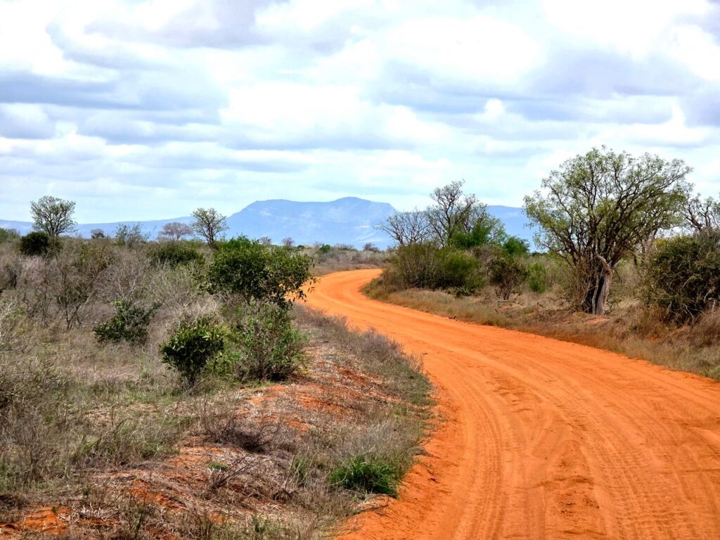 Staubige Straße durch die Savanne in Simbabwe